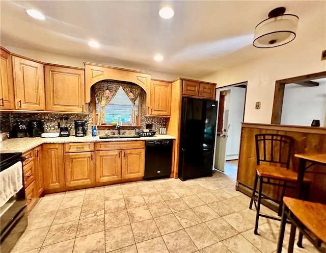 kitchen featuring sink, backsplash, and black appliances