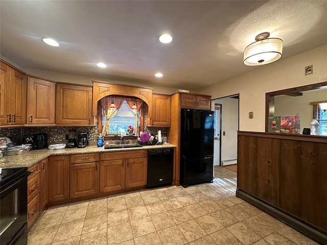 kitchen with baseboard heating, backsplash, sink, and black appliances