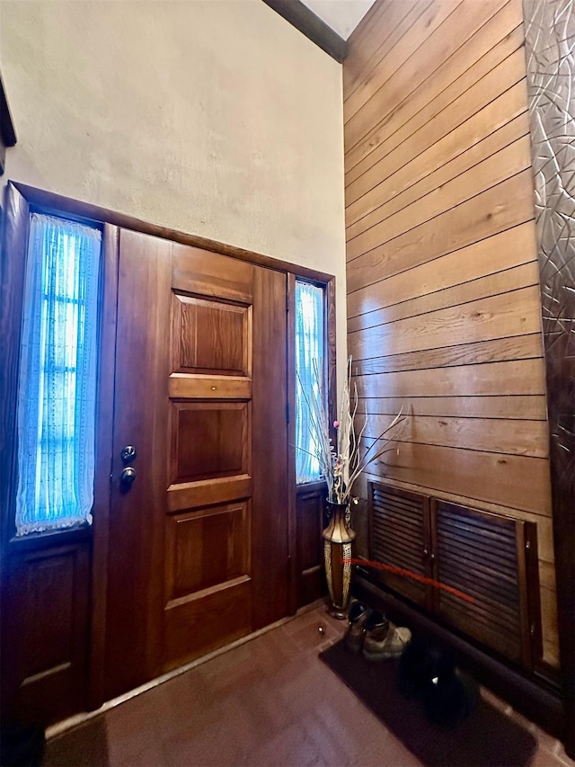 foyer with wood walls and carpet floors