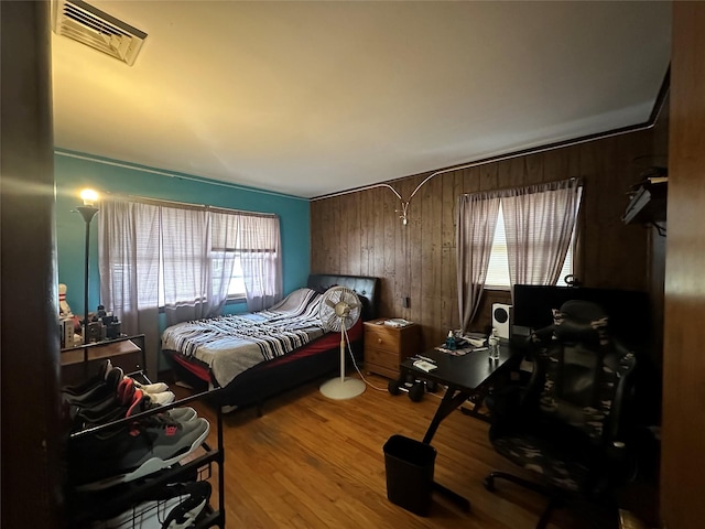 bedroom featuring hardwood / wood-style floors and wood walls