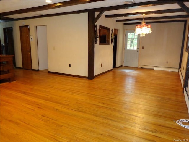 spare room featuring beamed ceiling, light hardwood / wood-style floors, and an inviting chandelier