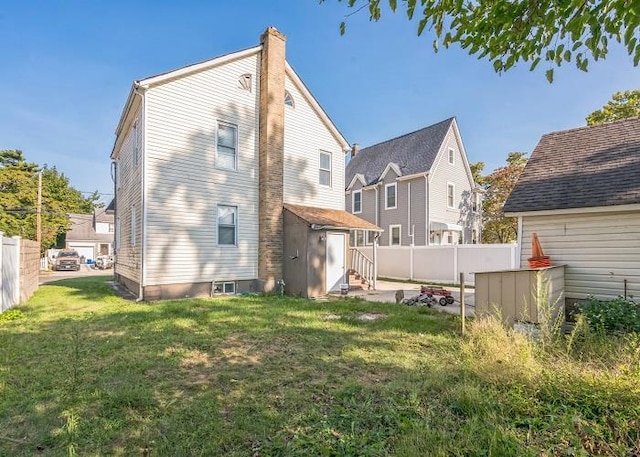 rear view of property featuring a lawn