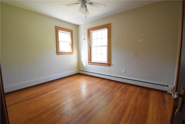 empty room featuring hardwood / wood-style flooring, baseboard heating, and ceiling fan