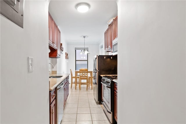 kitchen featuring sink, an inviting chandelier, pendant lighting, light tile patterned floors, and appliances with stainless steel finishes