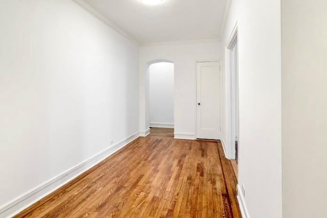 corridor featuring light wood-type flooring and ornamental molding