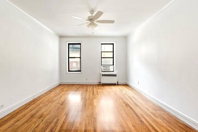 unfurnished room featuring ceiling fan, light wood-type flooring, ornamental molding, and radiator