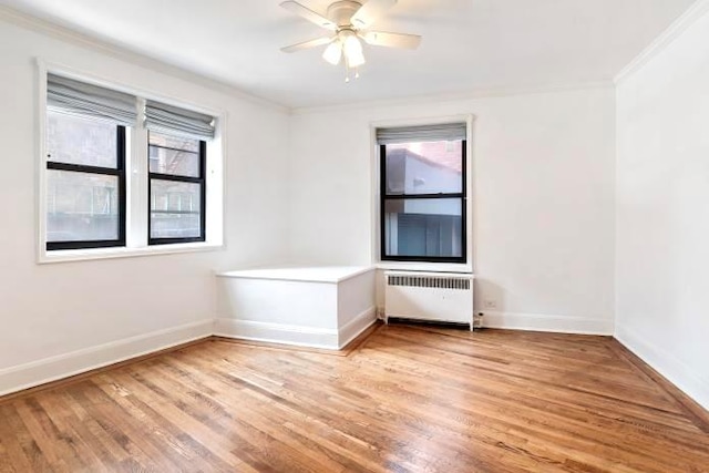 unfurnished room featuring radiator, ceiling fan, hardwood / wood-style floors, and ornamental molding