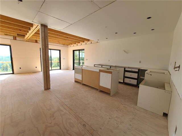 kitchen with a healthy amount of sunlight, a kitchen island, and white cabinetry