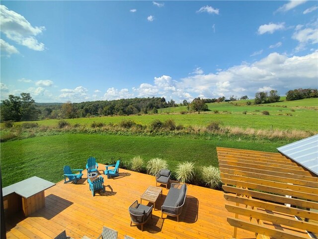 dock area with a rural view, a lawn, and a wooden deck