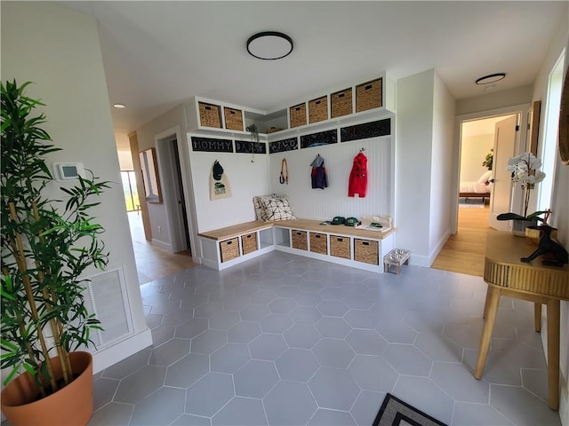 mudroom with dark tile patterned floors