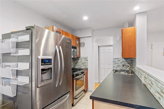 kitchen with light tile patterned floors, backsplash, stainless steel appliances, and sink