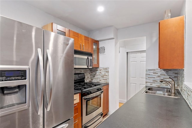 kitchen with tasteful backsplash, sink, and appliances with stainless steel finishes