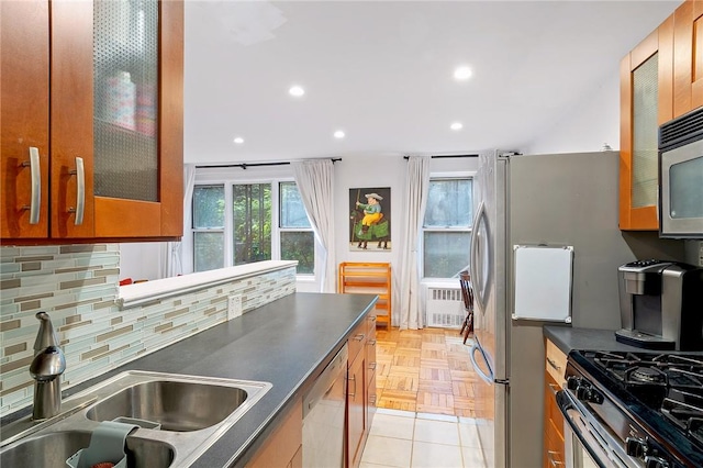 kitchen with tasteful backsplash, sink, light parquet floors, and appliances with stainless steel finishes