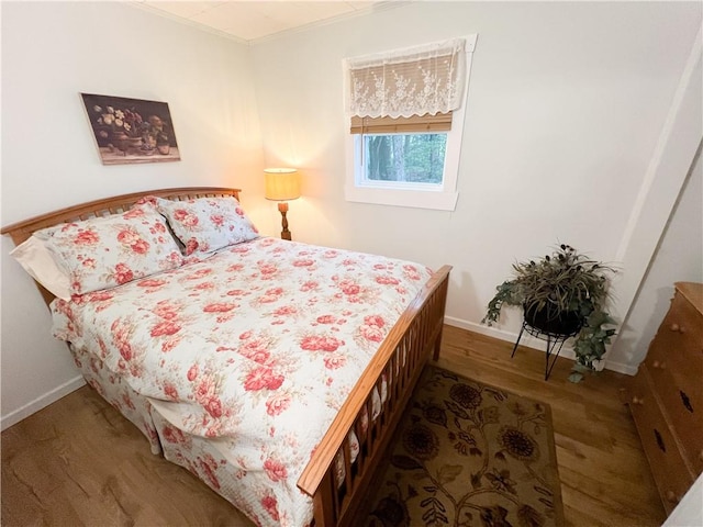 bedroom featuring wood-type flooring and ornamental molding