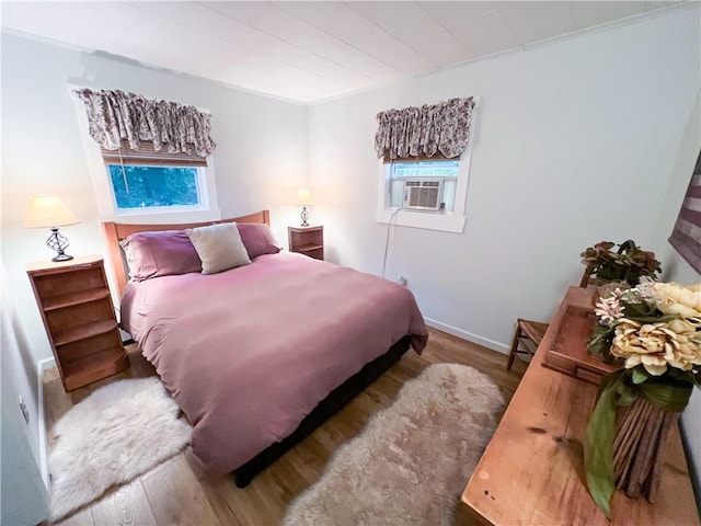 bedroom featuring hardwood / wood-style floors and cooling unit