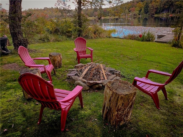 view of yard featuring a water view and an outdoor fire pit