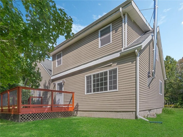 rear view of house with a deck and a yard