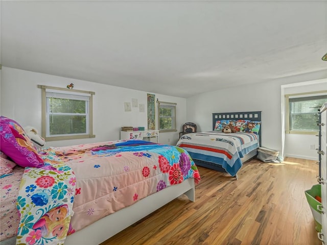 bedroom with hardwood / wood-style floors and multiple windows