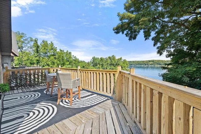 deck featuring outdoor dining area and a water view