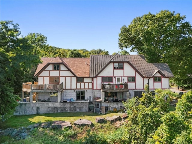 back of house featuring a lawn and a wooden deck