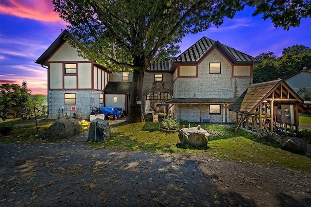 rear view of house with stone siding and stucco siding