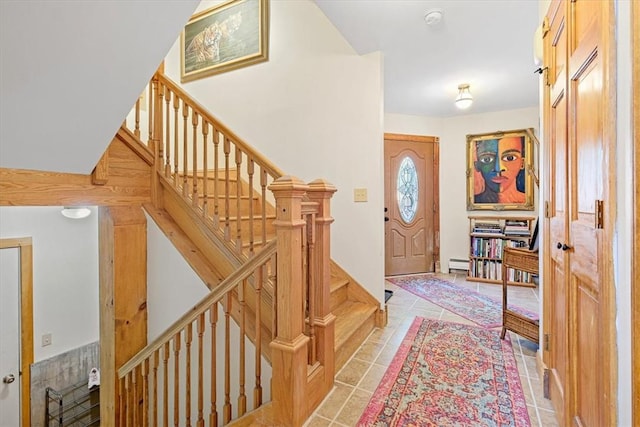 foyer with stairs, a baseboard heating unit, and light tile patterned flooring