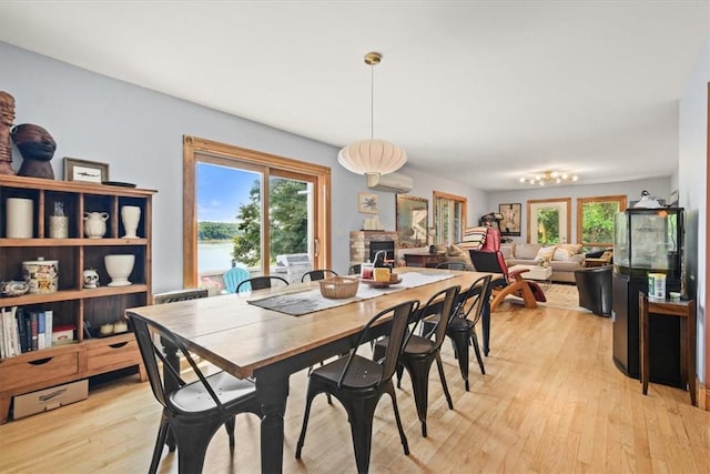 dining room with light wood-style flooring and a wall mounted AC