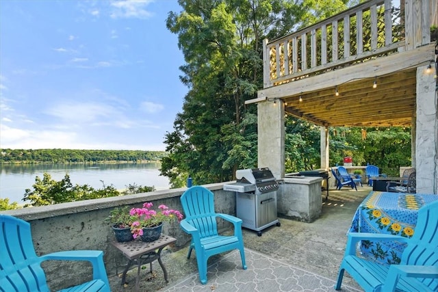 view of patio / terrace with a water view and area for grilling