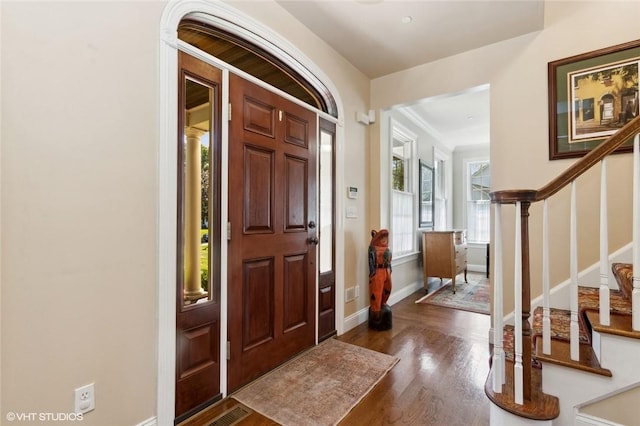 entrance foyer featuring crown molding and dark wood-type flooring