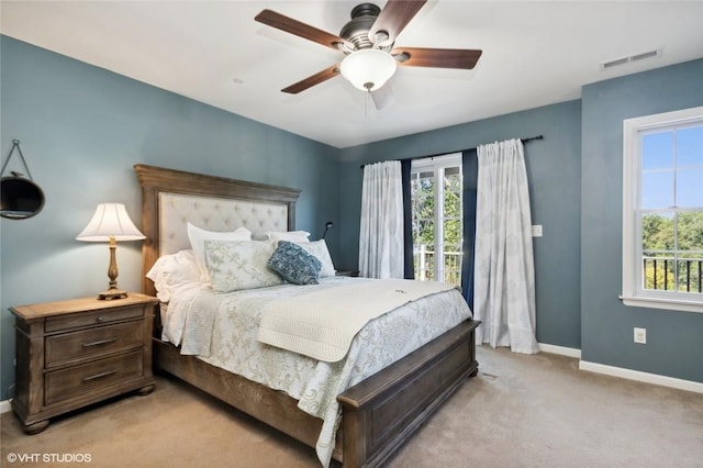 carpeted bedroom with ceiling fan and multiple windows