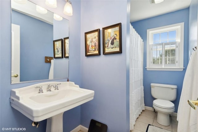 bathroom with toilet, tile patterned floors, and sink