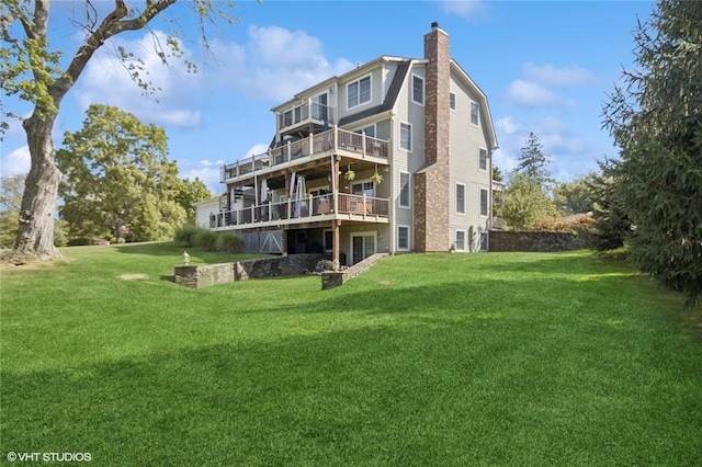 rear view of property with a yard, a balcony, and a deck