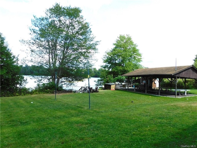 view of property's community with a gazebo, a water view, and a lawn