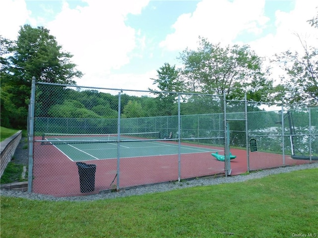 view of tennis court with a yard