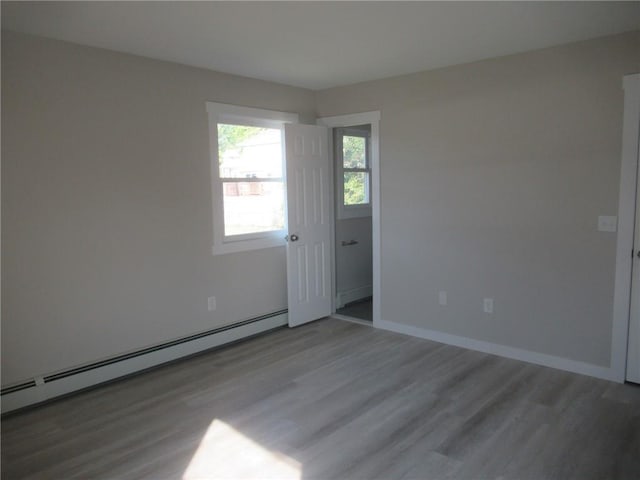 spare room featuring wood-type flooring and a baseboard radiator