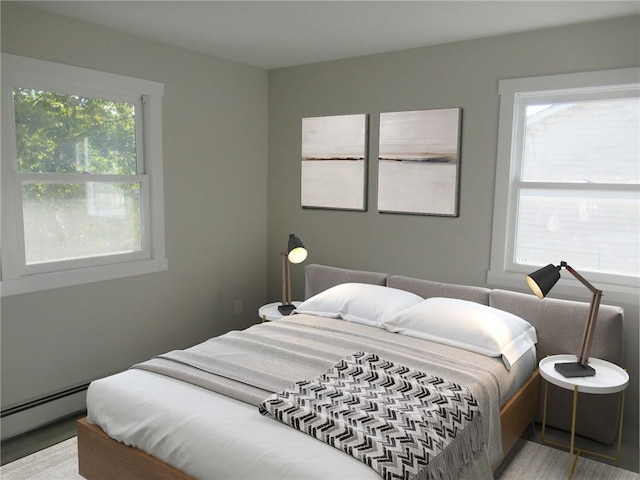 bedroom featuring hardwood / wood-style flooring and a baseboard heating unit