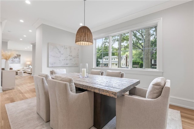 dining area with light hardwood / wood-style floors and crown molding