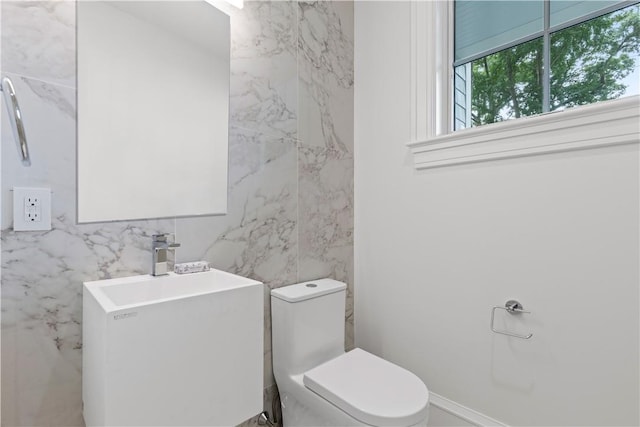 bathroom with toilet and tile walls