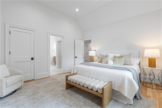 bedroom featuring light hardwood / wood-style flooring and high vaulted ceiling