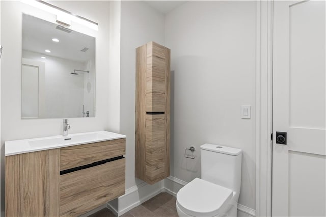 bathroom with vanity, toilet, and walk in shower