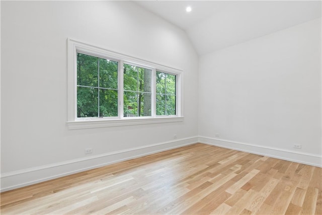 empty room featuring light hardwood / wood-style floors and vaulted ceiling