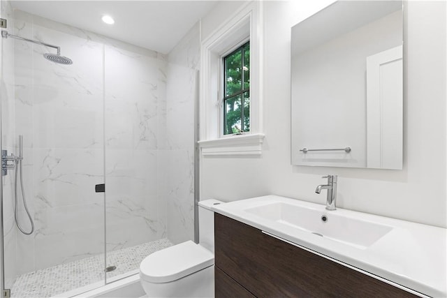 bathroom with vanity, toilet, and a shower with shower door