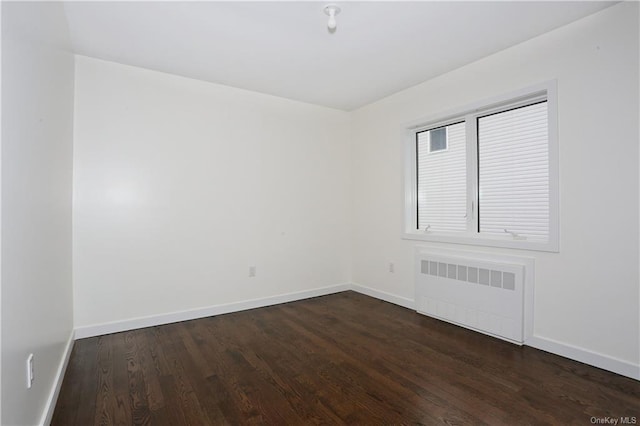 empty room featuring radiator heating unit and dark wood-type flooring