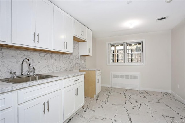 kitchen featuring white cabinets, decorative backsplash, and sink