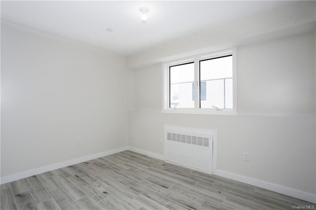 unfurnished room with light wood-type flooring and radiator