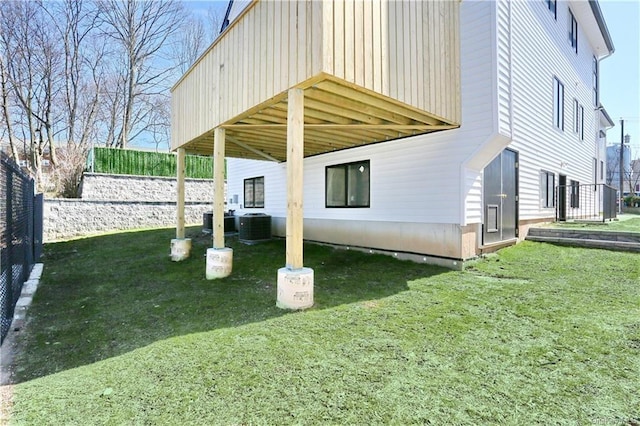 exterior space featuring a yard, a deck, and central AC unit