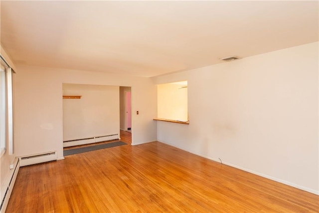 empty room featuring light hardwood / wood-style flooring and a baseboard heating unit