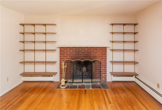 unfurnished living room featuring hardwood / wood-style flooring, a fireplace, and a baseboard radiator