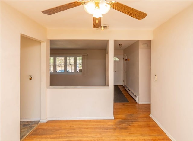 unfurnished room featuring ceiling fan, a baseboard radiator, and light hardwood / wood-style flooring