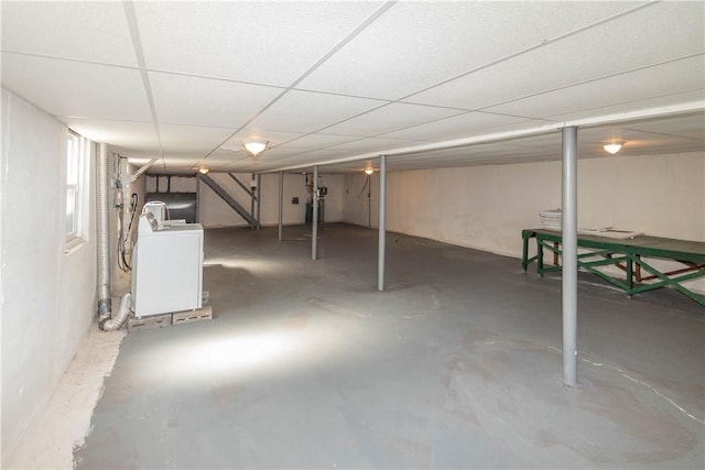 basement with a drop ceiling and washer / clothes dryer